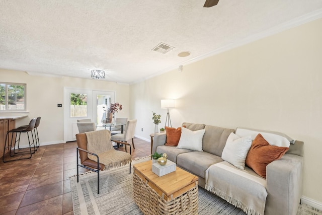 tiled living room featuring a wealth of natural light, french doors, crown molding, and a textured ceiling