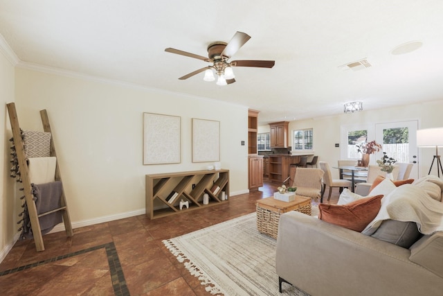 living room featuring ceiling fan with notable chandelier, dark tile patterned floors, and crown molding