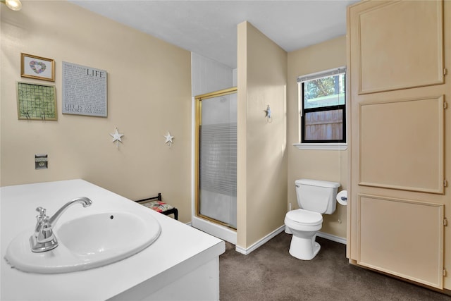 bathroom featuring vanity, toilet, and an enclosed shower