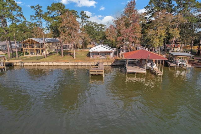 view of dock featuring a lawn and a water view