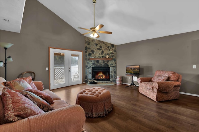 living room featuring ceiling fan, french doors, dark wood-type flooring, a stone fireplace, and high vaulted ceiling