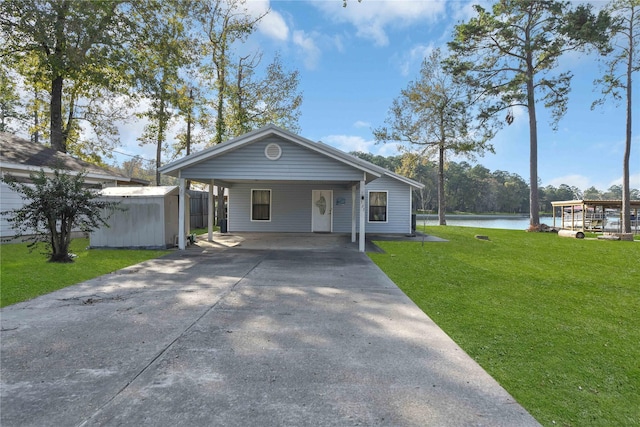 view of front facade with a front lawn, a water view, and a carport