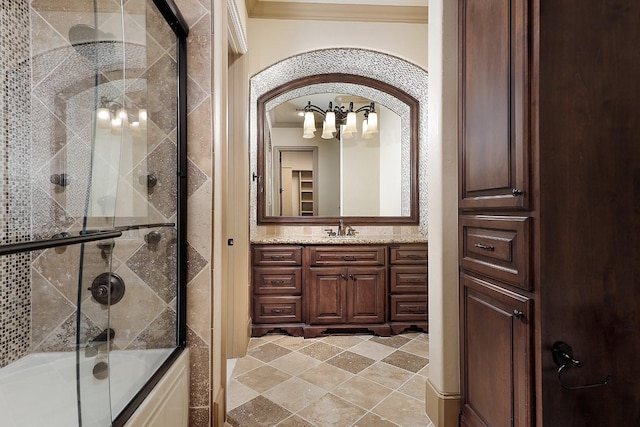 bathroom featuring combined bath / shower with glass door, vanity, and ornamental molding