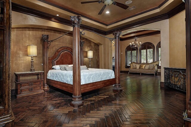 bedroom featuring dark parquet flooring, ceiling fan with notable chandelier, ornate columns, and crown molding