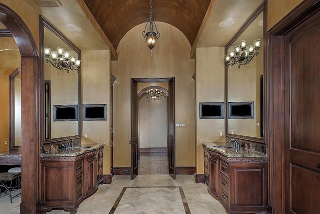 bathroom with vanity, vaulted ceiling, crown molding, a notable chandelier, and tile patterned flooring