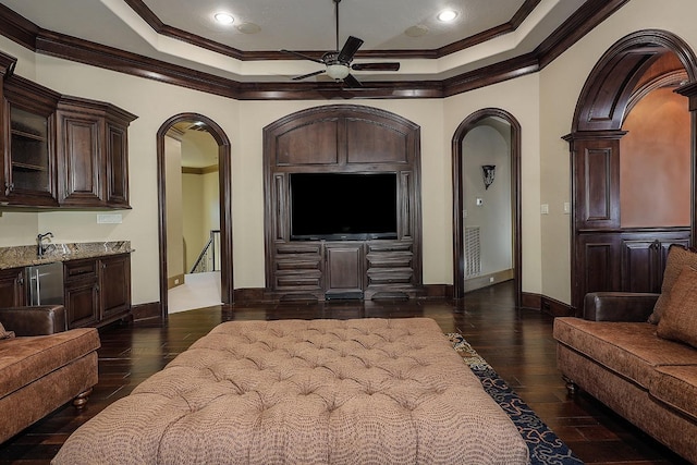 living room with ceiling fan, sink, dark wood-type flooring, and ornamental molding