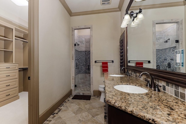 bathroom with crown molding, vanity, a shower with shower door, and toilet