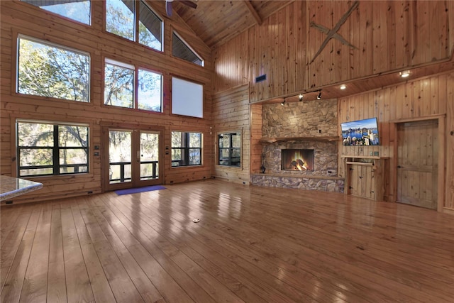 unfurnished living room with hardwood / wood-style floors and high vaulted ceiling