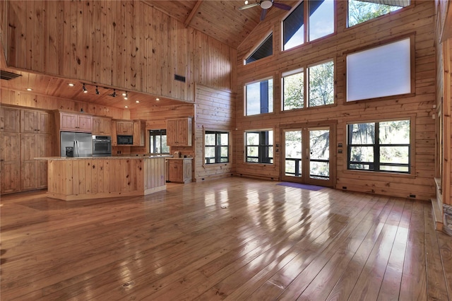 unfurnished living room featuring a wealth of natural light and high vaulted ceiling