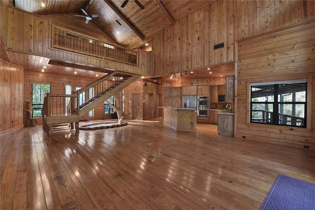 unfurnished living room with high vaulted ceiling, wood ceiling, and a wealth of natural light