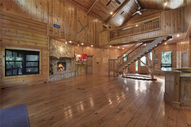 unfurnished living room with wooden ceiling, high vaulted ceiling, hardwood / wood-style flooring, ceiling fan, and beamed ceiling