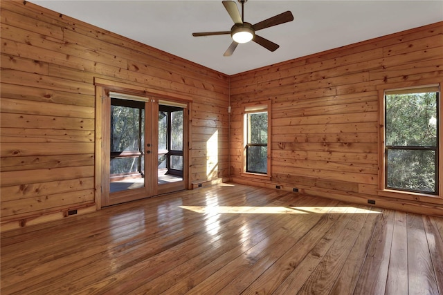 spare room with plenty of natural light, wood-type flooring, and french doors