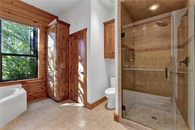 bathroom featuring tile patterned flooring, shower with separate bathtub, toilet, and wooden walls