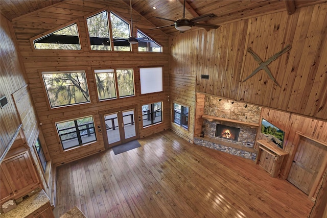 unfurnished living room featuring ceiling fan, a fireplace, high vaulted ceiling, and wooden ceiling