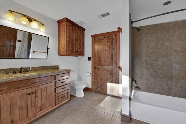 full bathroom with tile patterned floors, vanity, toilet, and tiled shower / bath combo