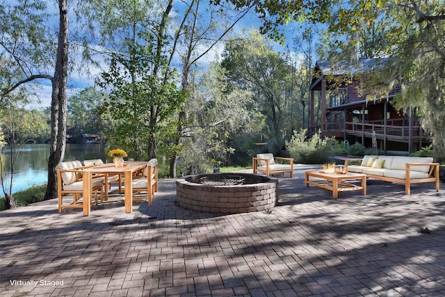 view of patio / terrace with a water view and an outdoor living space with a fire pit