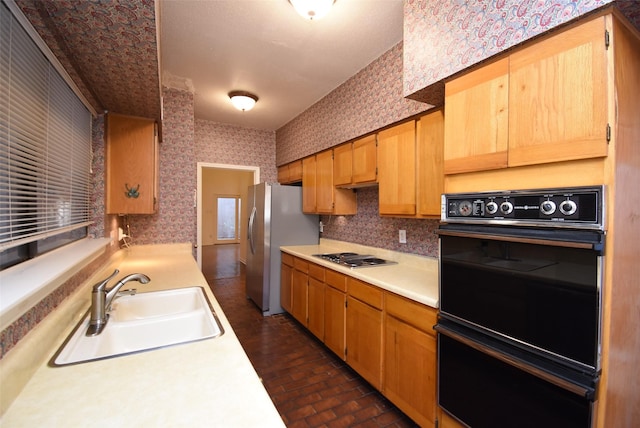 kitchen with stainless steel fridge, white gas cooktop, sink, and double oven