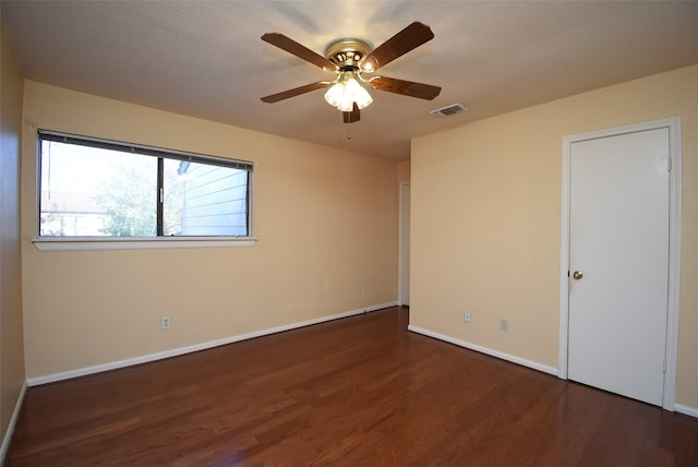 empty room featuring ceiling fan and dark hardwood / wood-style flooring