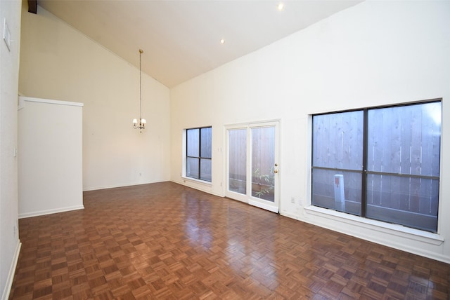 unfurnished room featuring a notable chandelier, dark parquet flooring, and high vaulted ceiling