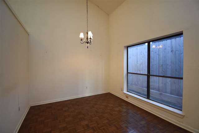 empty room with a chandelier, dark parquet flooring, and high vaulted ceiling