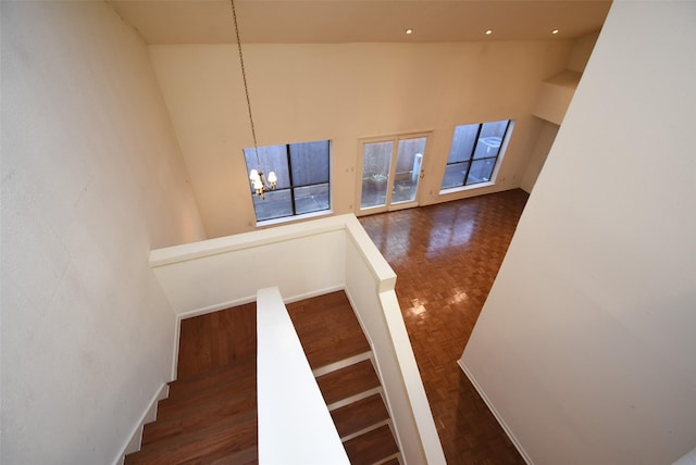 stairway featuring a chandelier and high vaulted ceiling