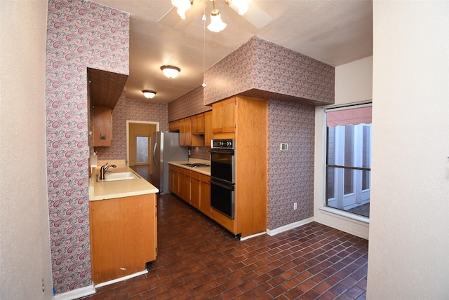 kitchen with double oven, stainless steel refrigerator, sink, and gas cooktop