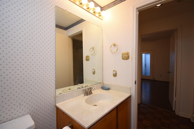 bathroom featuring crown molding, vanity, and wood-type flooring