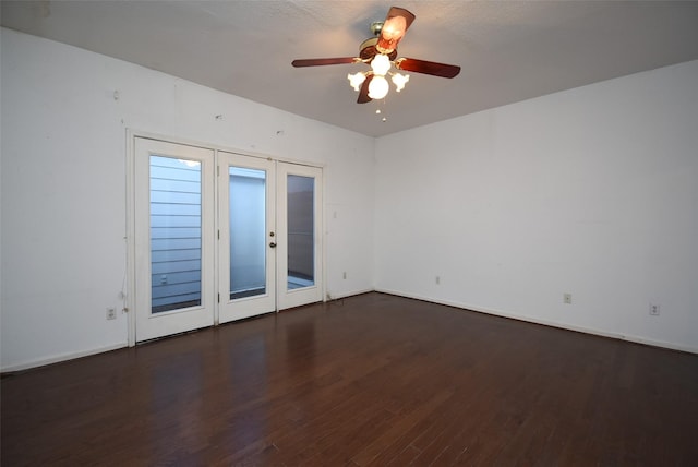 spare room with a textured ceiling, ceiling fan, dark hardwood / wood-style flooring, and french doors