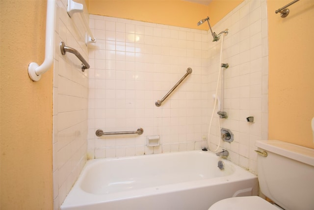 bathroom with tiled shower / bath combo and toilet