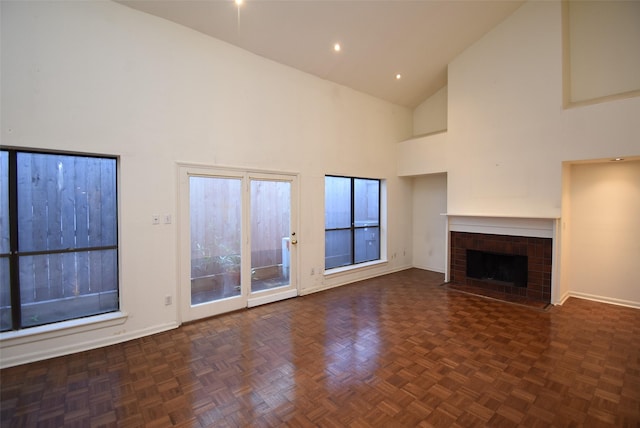 unfurnished living room with dark parquet flooring and high vaulted ceiling