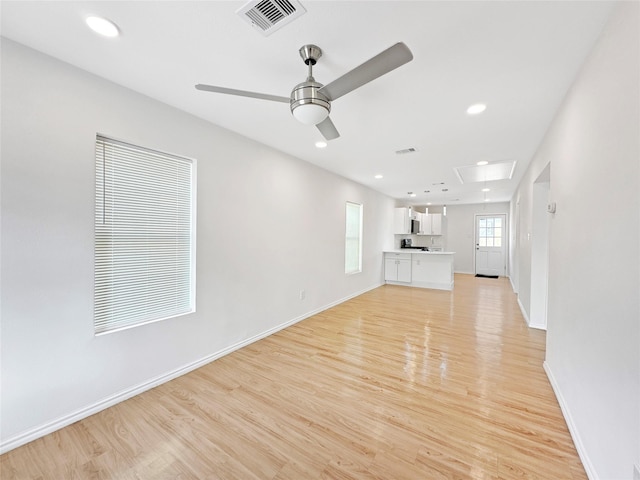 unfurnished living room with light wood-type flooring and ceiling fan