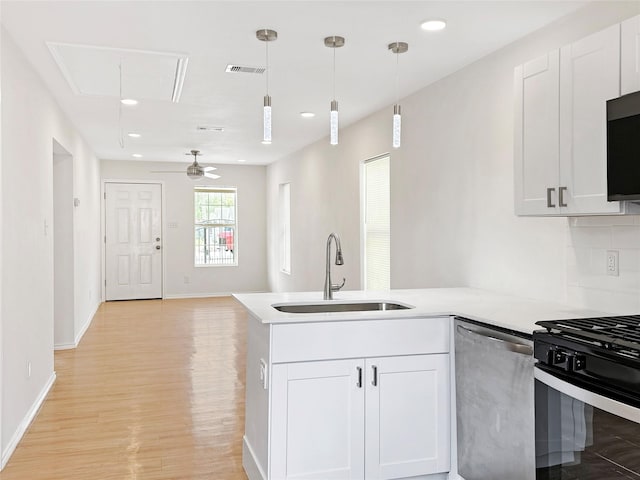 kitchen featuring pendant lighting, sink, ceiling fan, appliances with stainless steel finishes, and white cabinetry