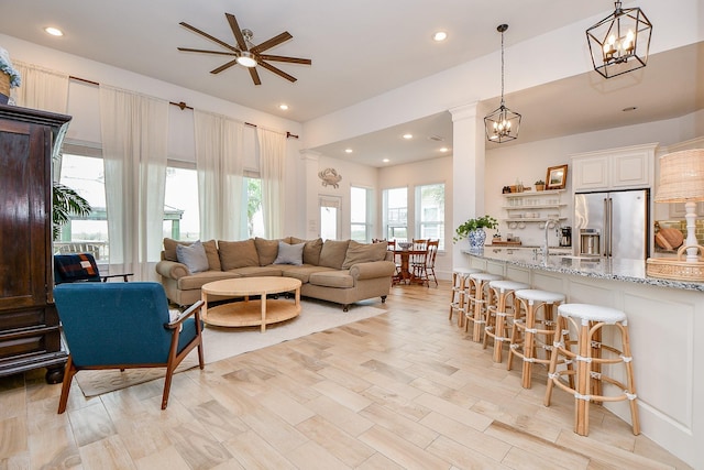 living room featuring a wealth of natural light, sink, ceiling fan, and light hardwood / wood-style floors