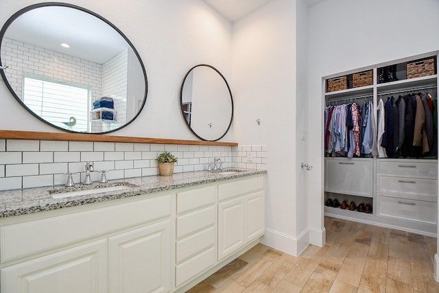 bathroom with hardwood / wood-style flooring, vanity, and backsplash