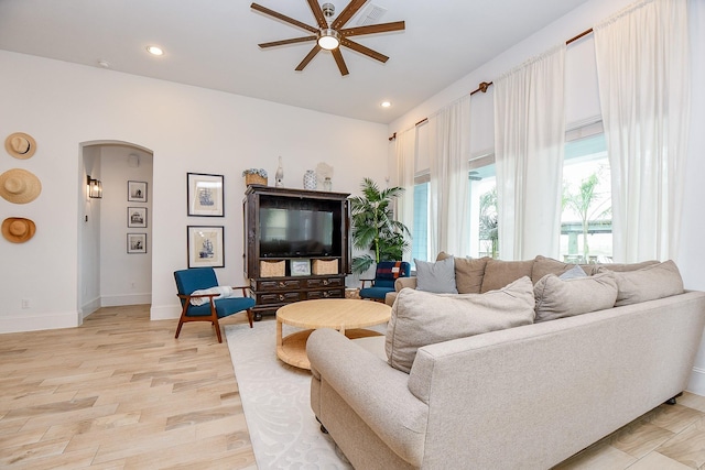 living room with ceiling fan and light hardwood / wood-style flooring