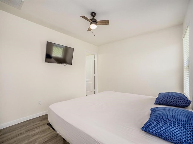 bedroom with hardwood / wood-style flooring, ceiling fan, and multiple windows