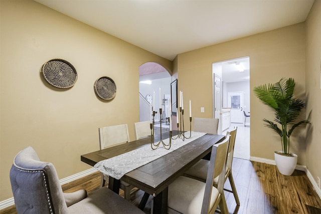 3102 Silver Cedar Trl, Katy, TX 77449 - dining area with arched walkways, wood finished floors, and baseboards