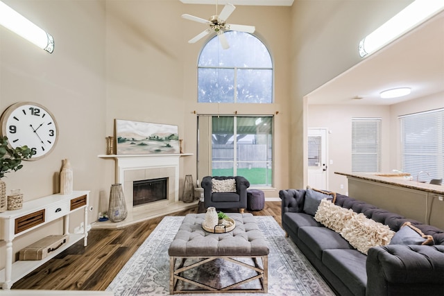 3102 Silver Cedar Trl, Katy, TX 77449 - living room with a towering ceiling, dark wood-style flooring, ceiling fan, and a fireplace