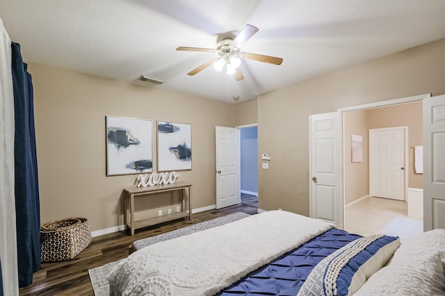 bedroom featuring ceiling fan, dark hardwood / wood-style flooring, and a textured ceiling