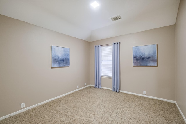 carpeted empty room featuring lofted ceiling