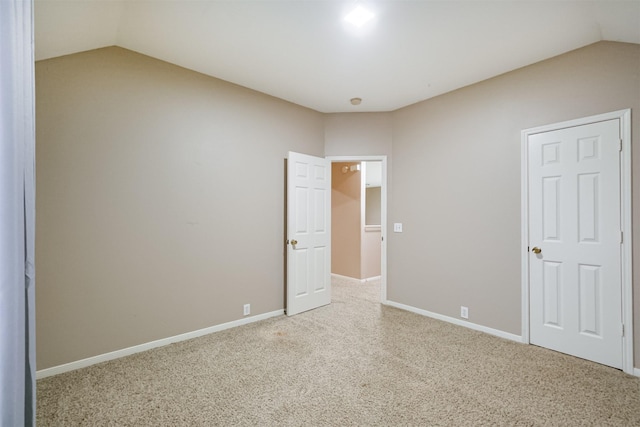 unfurnished bedroom featuring carpet floors and vaulted ceiling