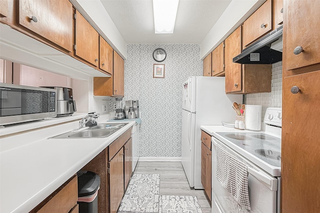 kitchen featuring white range with electric stovetop, decorative backsplash, sink, and light hardwood / wood-style flooring