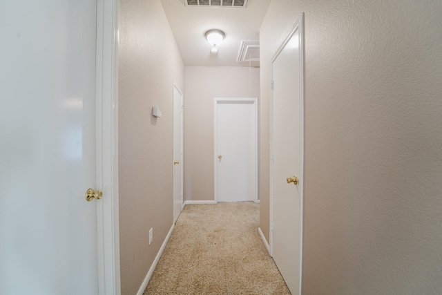 hallway featuring light colored carpet