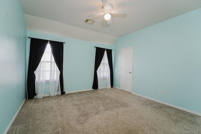 carpeted spare room featuring ceiling fan and vaulted ceiling