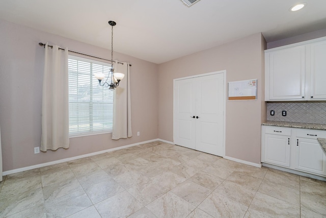 unfurnished dining area featuring a notable chandelier