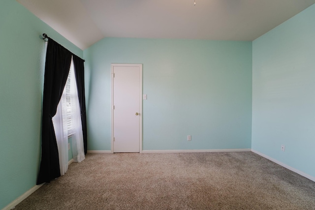 unfurnished room with carpet flooring and vaulted ceiling