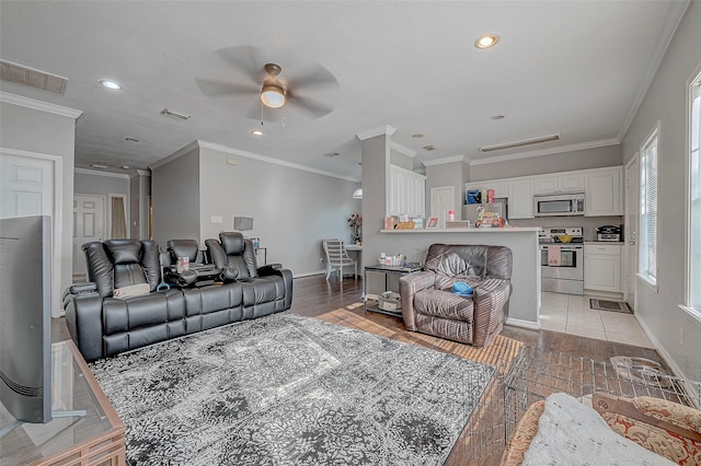 living room with crown molding, ceiling fan, and light hardwood / wood-style floors