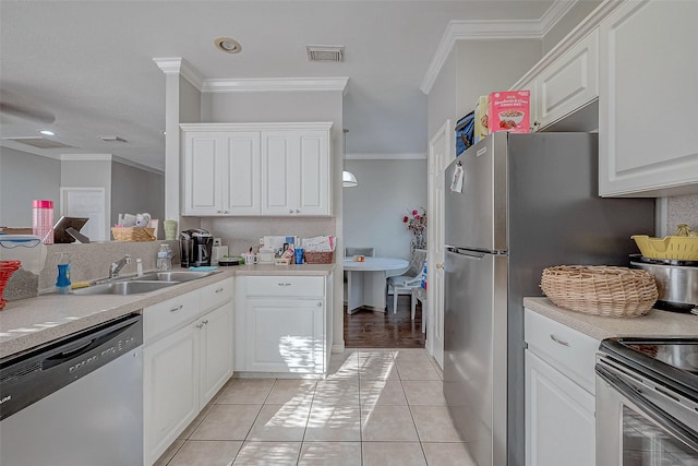 kitchen with light tile patterned flooring, appliances with stainless steel finishes, sink, and white cabinets