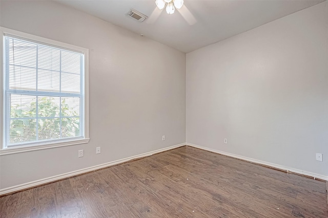 spare room featuring a healthy amount of sunlight, hardwood / wood-style floors, and ceiling fan