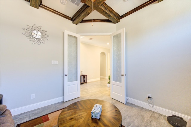 interior space with french doors, beamed ceiling, light hardwood / wood-style floors, and ornamental molding